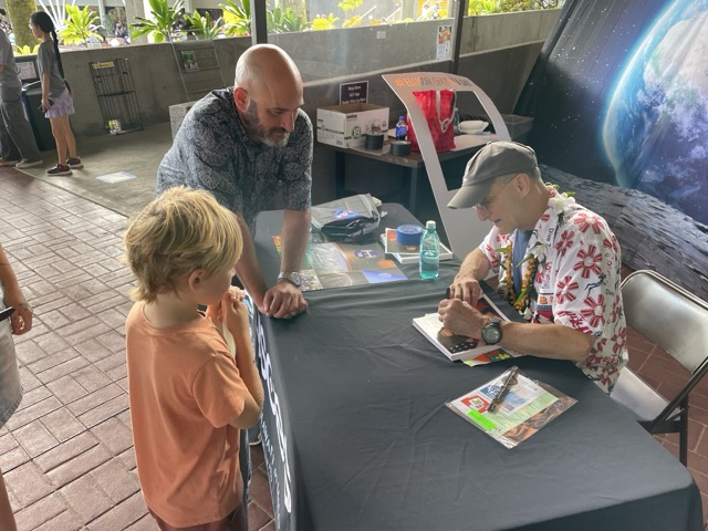Astronaut Donald Pettit autographs a photo of himself for keiki at Onizuka Day.